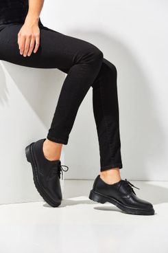 A black 1461 3-eye Oxford style pair of Dr. Martens with a subtle black platform and visible stitching shown on a model wearing high waisted black jeans. The Strategist - 48 Things on Sale You’ll Actually Want to Buy: From Sunday Riley to Patagonia