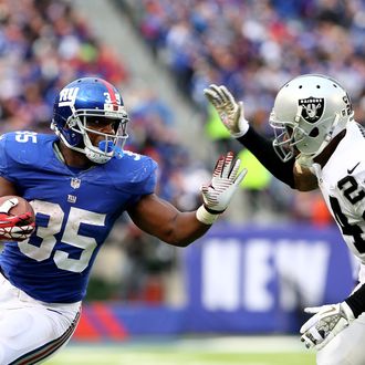 Andre Brown #35 of the New York Giants carries the ball as Charles Woodson #24 of the Oakland Raiders defends at MetLife Stadium on November 10, 2013 in East Rutherford, New Jersey.The New York Giants defeated the Oakland Raiders 24-20. 