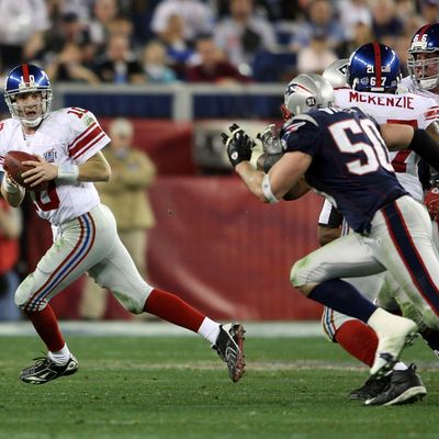 GLENDALE, AZ - FEBRUARY 03: Eli Manning #10 of the New York Giants scrambles away from th New England Patriots defense to throw a 32 yard pass to David Tyree #85 of the Giants during the four quarter of Super Bowl XLII on February 3, 2008 at the University of Phoenix Stadium in Glendale, Arizona. (Photo by Andy Lyons/Getty Images)