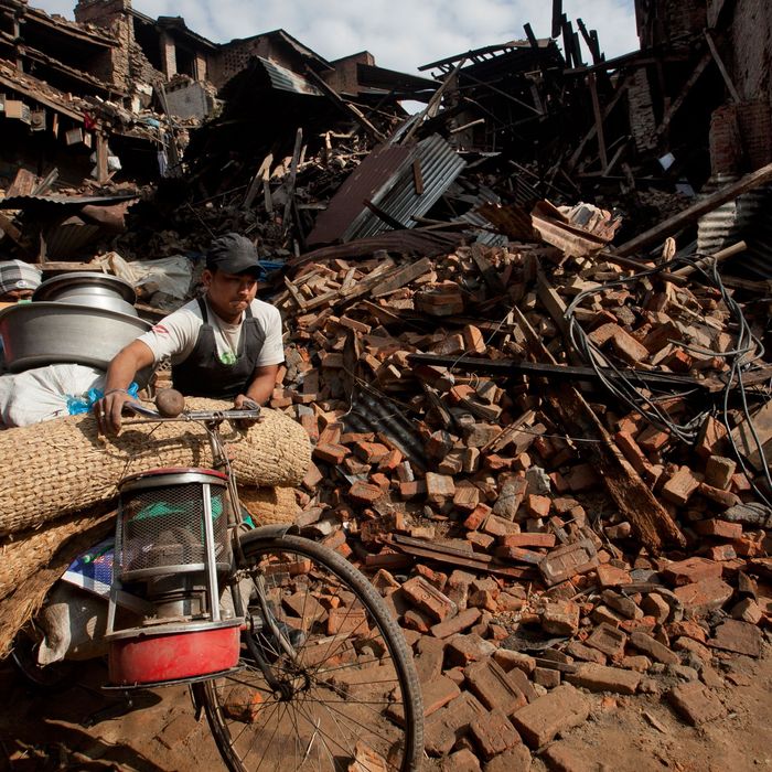 People walk past damage caused by Saturday's earthquake in Bhaktapur, on the outskirts of Kathmandu, Nepal, Monday, April 27, 2015. A strong magnitude earthquake shook Nepal’s capital and the densely populated Kathmandu valley on Saturday devastating the region and leaving tens of thousands shell-shocked and sleeping in streets. (AP Photo/Niranjan Shrestha)