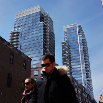 NEW YORK, NY - APRIL 04: People walk by new apartment buildings near the waterfront in the rapidly developing neighborhood of Williamsburg on April 4, 2013 in the Brooklyn borough of New York City. Two Trees management, which owns the closed Domino Sugar factory, has unveiled new plans for the site that will include more than half a million square feet of office space, 228,000 square feet of open space and 2,284 apartments and retail space. The plan is a continuation of the rapid development of the Williamsburg waterfront which offers Manhattan views and water taxis to other parts of New York City. (Photo by Spencer Platt/Getty Images)