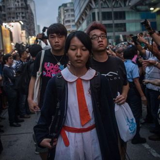 HONG KONG - OCTOBER 03: Students and pro-democracy activists leave the protest site as local police hold back local residents and pro-government supporters on October 3, 2014 in Mong Kok, Hong Kong. Fights broke out between local residents and pro government supporters when they attempted to force pro-democracy activists from their protest site. Thousands of pro democracy supporters continue to occupy the streets surrounding Hong Kong's Financial district. Protest leaders have set an October 1st deadline for their demands to be met and are calling for open elections and the resignation of Hong Kong's Chief Executive Leung Chun-ying. (Photo by Chris McGrath/Getty Images)