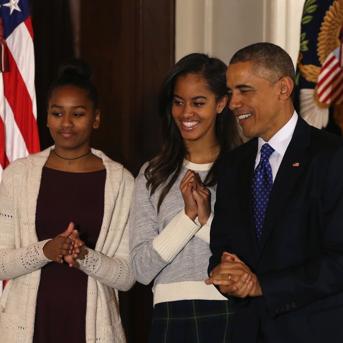 WASHINGTON, DC - NOVEMBER 26: U.S. President Barack Obama (R) stands with his daughters Sasha (L) and Malia after he pardoned 