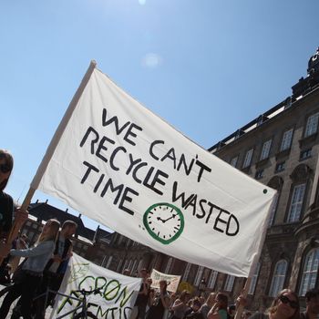 Denmark, Copenhagen: Two demonstrators hold a banner with the inscription “We Can’t Recycle Wasted Time” in front of the Danish Parliament during a climate protest.