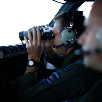 IN FLIGHT - MARCH 29: Wing Commander Rob Shearer looks through binoculars on the flight deck of a Royal New Zealand Air Force P-3K2 Orion aircraft searching for missing Malaysian Airlines flight MH370 on March 29, 2014 over the southern Indian Ocean. Chinese ships trawled a new area in the Indian Ocean for a missing Malaysian passenger jet on Saturday, as the search for Flight MH370 entered its fourth week amid a series of false dawns over sightings of debris. The Malaysian airliner disappeared on March 8 with 239 passengers and crew on board and is suspected to have crashed into the southern Indian Ocean. (Photo by Jason Reed-Pool/Getty Images)