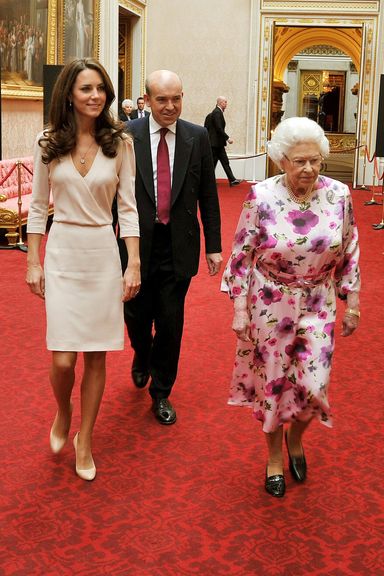 LONDON, UNITED KINGDOM - JULY 22: Britain’s Queen Elizabeth II  walks with Catherine, Duchess of Cambridge as they view the exhibitions for the summer opening of Buckingham Palace on July 22, 2011 in London, England. The Duchess of Cambridge’s intricately decorated wedding dress, designed by Sarah Burton of Alexander McQueen is currently on display at Buckingham Palace (Photo by John Stillwell - WPA Pool/Getty Images)