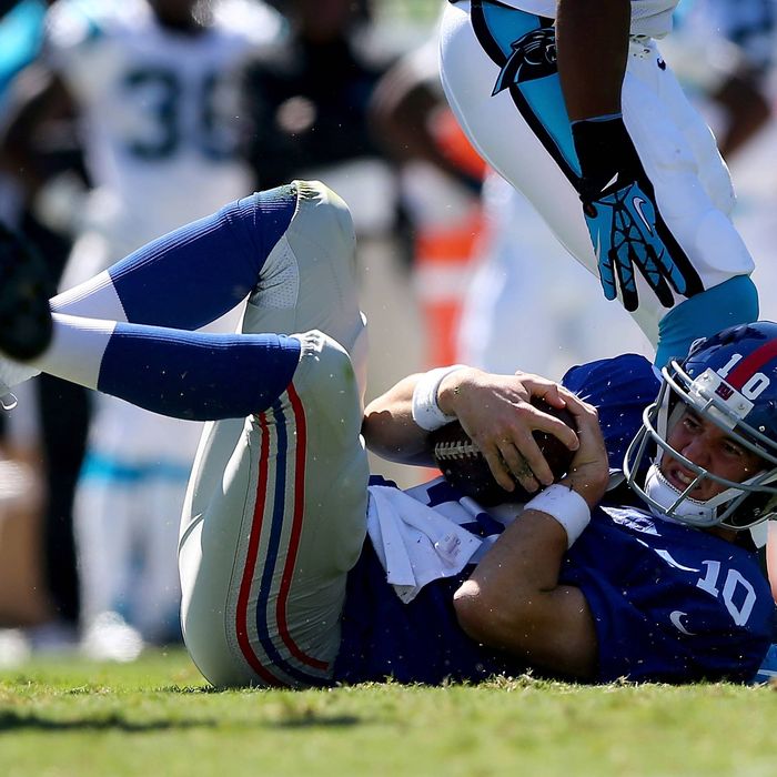 CHARLOTTE, NC - SEPTEMBER 22: Eli Manning #10 of the New York Giants is knocked to the ground during their game against the Carolina Panthers at Bank of America Stadium on September 22, 2013 in Charlotte, North Carolina. (Photo by Streeter Lecka/Getty Images)