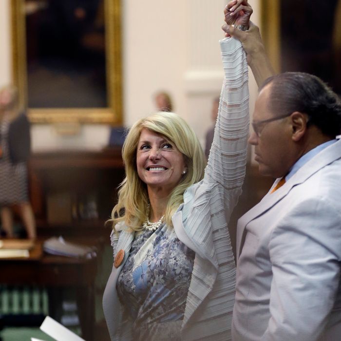 Sen. Wendy Davis, D-Fort Worth, left, who tries to filibuster an abortion bill, reacts as time expires, Tuesday, June 26, 2013, in Austin, Texas. Amid the deafening roar of abortion rights supporters, Texas Republicans huddled around the Senate podium to pass new abortion restrictions, but whether the vote was cast before or after midnight is in dispute. If signed into law, the measures would close almost every abortion clinic in Texas. (AP Photo/Eric Gay)