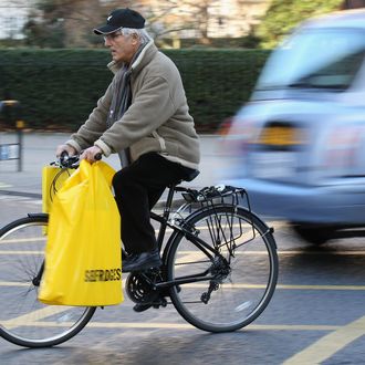 A man cycles with shopping bags on his bike .
