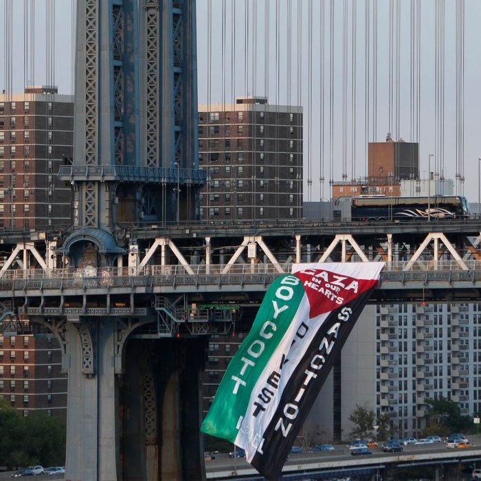 Demonstrators hang a protest flag from the south side of the Manhattan Bridge as a pro-Palestinian rally (not pictured) makes its way across the nearby Brooklyn Bridge, Wednesday, Aug. 20, 2014, in New York. (AP Photo/Jason DeCrow)