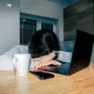 Tired and upset woman works in a home office at night