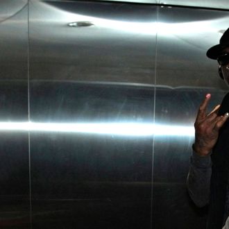 Former NBA star Dennis Rodman gestures to journalists in an elevator as he arrives at the Beijing Capital International Airport after his visit to Democratic People's Republic of Korea (DPRK), March 1, 2013.