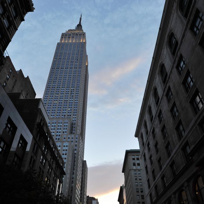 Past the Empire State Building (L), the sun sets along 34th Street aligning with the Manhattan street grid during