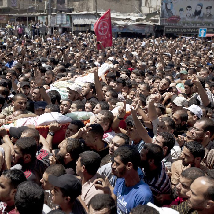 Palestinian mourners carry the bodies of three senior Hamas commanders during their funeral in the southern Gaza Strip town of Rafah on August 21,2014. Israeli warplanes killed three top Hamas commanders in southern Gaza inflicting a heavy blow on the movement's armed wing after failing to kill its top military chief. AFP PHOTO / MAHMUD HAMS (Photo credit should read MAHMUD HAMS/AFP/Getty Images)