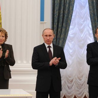 MOSCOW, RUSSIA - MARCH 21: Sergey Naryshkin (R) Chairman of the State Duma and Valentina Matviyenko (L) the Chairwoman of the Federation Council of the Russian Federation stand next to the Russian President Vladimir Putin as he signs set of laws on reunification of Crimea, Sevastopol with Russia at Ekaterininsky in Kremlin, March 21, 2014. 