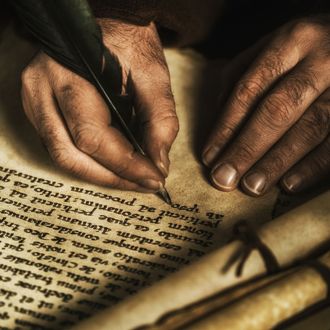 Hands writing on parchment