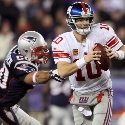 Eli Manning #10 of the New York Giants scrambles as Rob Ninkovich #50 of the New England Patriots defends on November 6, 2011 at Gillette Stadium in Foxboro, Massachusetts.