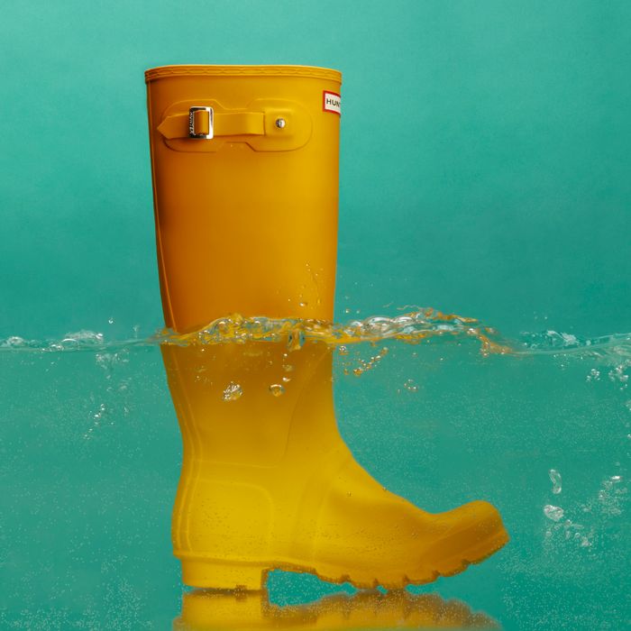 Women's rain boot stepping into a puddle