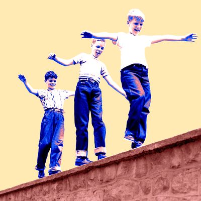 1950s Laughing Boys Walking On Top Of Stone Wall Arms Out Balancing Playing Follow The Leader.
