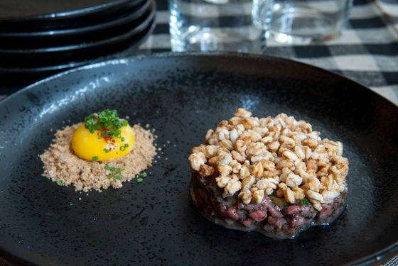 Beef tartare: black trumpet mushrooms, puffed farro, anchovy, and egg yolk.