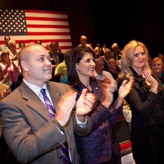 CHARLESTON, SC - DECEMBER 17: South Carolina Gov. Nikki Haley (C) with Ann Romney, wife of Republican presidential candidate former Massachusetts Gov. Mitt Romney and Michael Haley applaud after a town hall meeting at the Memminger Auditorium on December 17, 2011 in Charleston, South Carolina. Romney is attempting to boost the momentum of his campaign following the conservative endorsement of South Carolina Gov. Nikki Haley. (Photo by Richard Ellis/Getty Images)