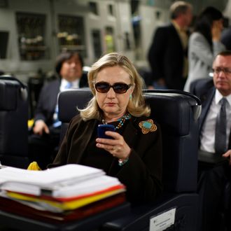 U.S. Secretary of State Hillary Clinton checks her PDA upon departure in a military C-17 plane from Malta bound for Tripoli, on October 18, 2011. AFP PHOTO/KEVIN LAMARQUE/POOL (Photo credit should read KEVIN LAMARQUE/AFP/Getty Images)