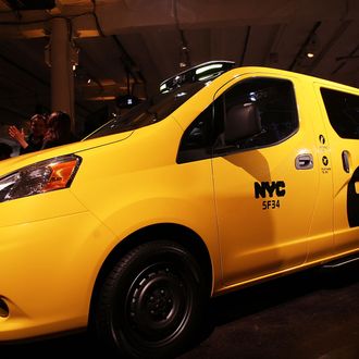 People look at the new New York City taxi which is designed by the Nissan Motor Co. at an official unveiling on April 3, 2012 in New York City. The new taxis, which will start appearing on the streets of New York next year, service an estimated service 600,000 people daily. The 2014 NV200 Taxi will replace the fleet of iconic Ford Crown Victorias, Ford Escape Hybrids and Toyota Siennas that are currently being used. Some of the highlights of the new taxi include front and rear-seat occupant curtain airbags, a window on the roof, backseat cellphone charging and USB ports and passenger reading lights. (Photo by Spencer Platt/Getty Images)