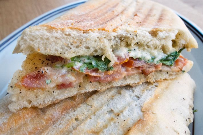 Smoked-bacon panino with tomato, arugula, and Asiago.