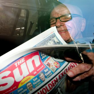 News Corporation Chief Rupert Murdoch holds up a copy of the newly launched 'The Sun on Sunday' newspaper as he leaves his London home on February 26, 2012. Rupert Murdoch's Sun on Sunday tabloid hit news stands on Sunday, replacing the defunct News of the World with a pledge to meet high ethical standards after a 