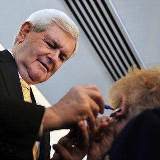 Republican presidential hopeful Newt Gingrich (L) autographs the earrings of Judy Youngblood (R) at a rally on January 30, 2012 at the Hyatt Regency Jacksonville Riverfront hotel in Jacksonville, Florida. AFP PHOTO/Stan HONDA (Photo credit should read STAN HONDA/AFP/Getty Images)