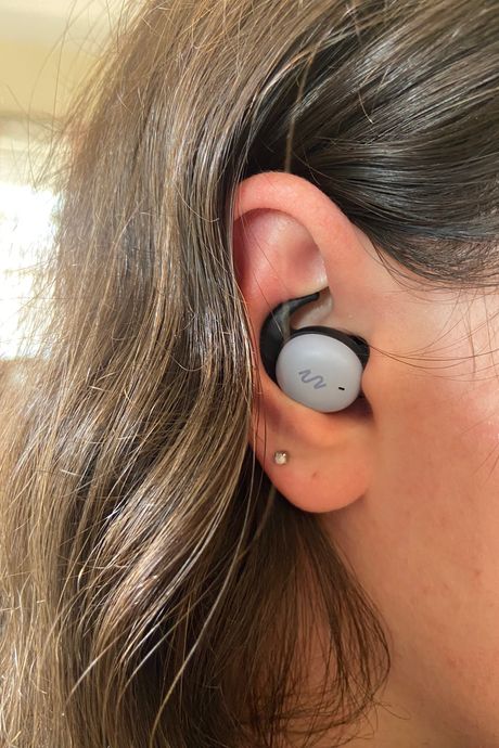 An earbud in a person's ear.