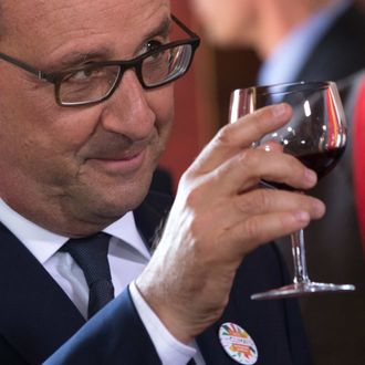 French President Francois Hollande raises a glass for a toast during a Tastevin confraternity induction ceremony at the Chateau Clos Vougeot, in the Burgundy wine region