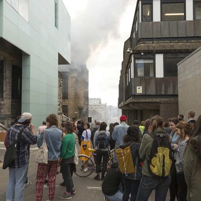 Glasgow, United Kingdom. 23rd May 2014 -- Larger crowds start to gather from neighbouring offices. -- The Charles Rennie Mackintosh designed Glasgow School of art is currently on fire with emergency services crews in attendance.