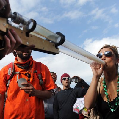 DENVER, CO - APRIL 19: Kimberly Bullard, 23, of Los Angeles, California takes a hit off a I420 Double Barrel Shotgun pipe during the High Times Cannabis Cup at the Denver Mart in Denver, Colorado on April 19, 2015. The High Times Cannabis Cup runs through Monday at the Denver Mart. (Photo by Seth McConnell/The Denver Post via Getty Images)