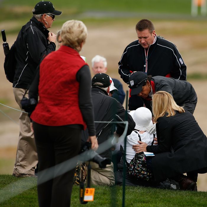 Former Secretary of State Condoleezza Rice (C) checks on the fan she struck with her golf ball on the sixth hole during the first round of the AT&T Pebble Beach National Pro-Am at Pebble Beach Golf Links on February 7, 2013 in Pebble Beach, California.