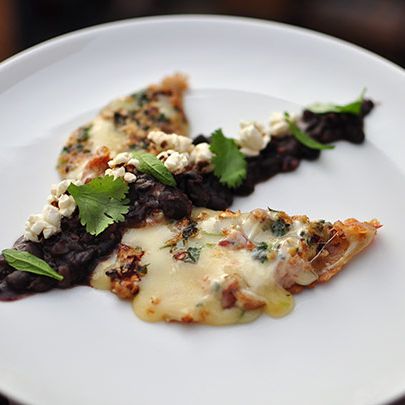 La Luna是一种月亮形状的房屋玉米饼和融化的奶酪，加上炸瓜西罗、芝麻、爆米花、香草和黑豆制成的脆脆的月球景观。