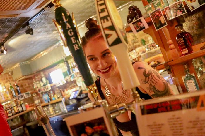 Bartender at the bar of the student pub 'Sehnsucht' in the