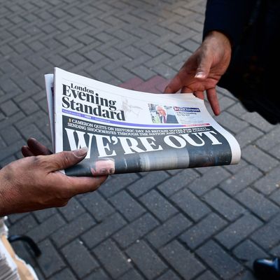 A man takes a copy of the London Evening Standard with the front page reporting the resignation of British Prime Minister David Cameron and the vote to leave the EU in a referendum, showing a pictured of Cameron holding hands with his wife Samantha as they come out from 10 Downing Street, in London on June 24, 2016. 
