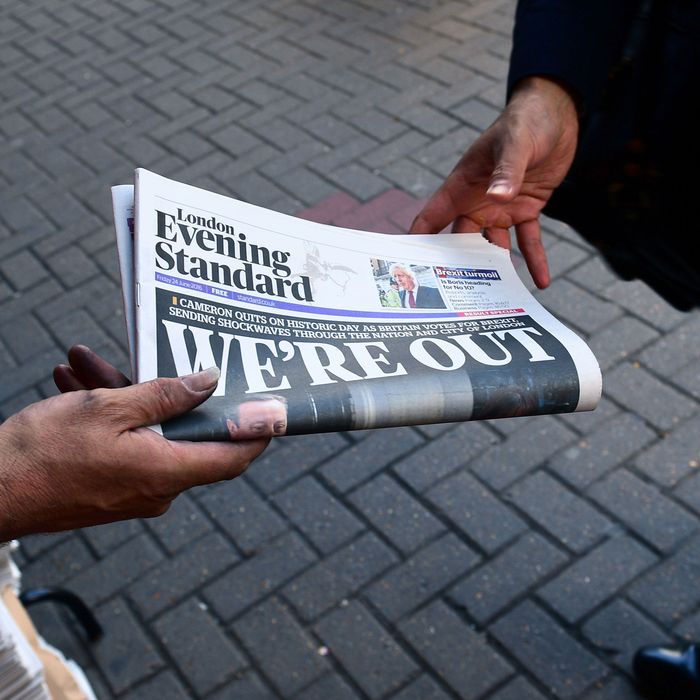 A man takes a copy of the London Evening Standard with the front page reporting the resignation of British Prime Minister David Cameron and the vote to leave the EU in a referendum, showing a pictured of Cameron holding hands with his wife Samantha as they come out from 10 Downing Street, in London on June 24, 2016.