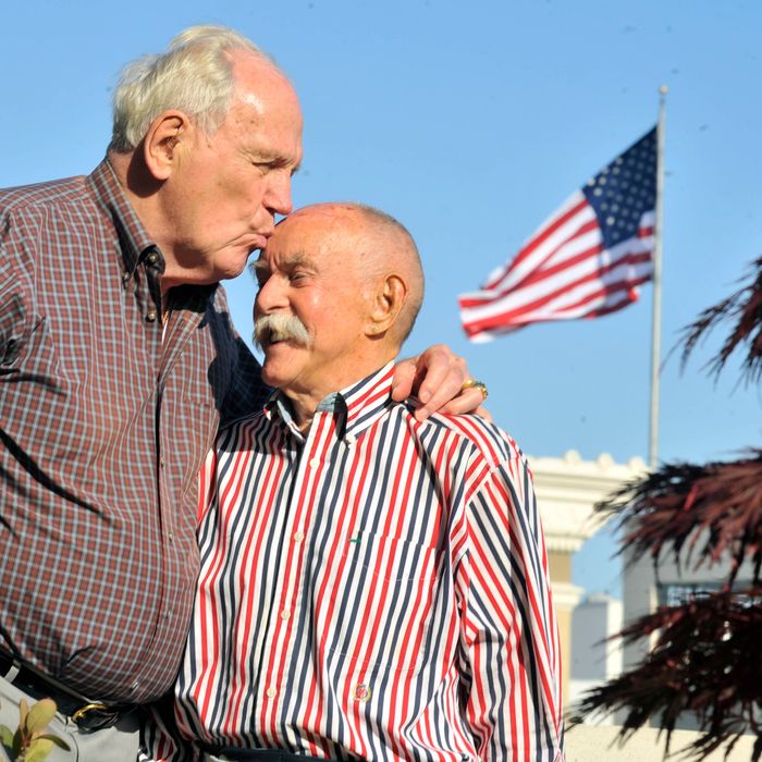 John Darby (L) kisses his husband Jack Bird (R) at their home in San Francisco, California on May 02, 2013. This year, the couple will celebrate 54 years of being together and five years of marriage. 
