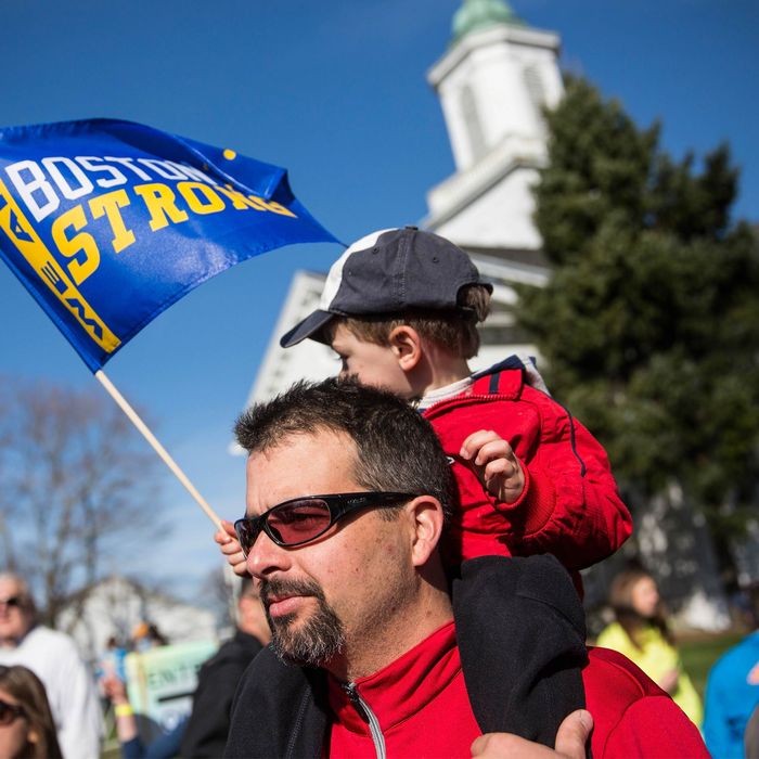 HOPKINGTON, MA - APRIL 21: A father carrying his son on his shoulder watches the scene at the starting line of the Boston Marathon on April 21, 2014 in Hopkington, Massachusetts. Today marks the 118th Boston Marathon; security presence has been increased this year, due to two bombs that were detonated at the finish line last year, killing three people and injuring more than 260 others. (Photo by Andrew Burton/Getty Images)