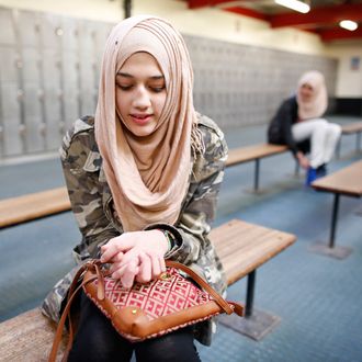 Ameera, 12, waits to go ice skating in east London March 8, 2014. Ameera first wore the hijab as part of her primary school uniform. She started to wear it full time age 9 because most of her friends wore the hijab. Her mother would tell her 