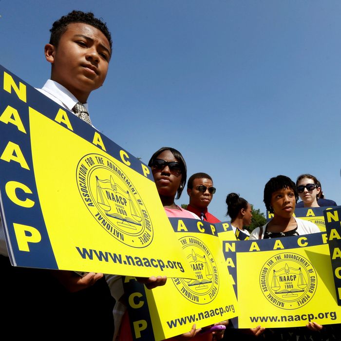 Supporters of the National Association for the Advancement of Colored People (NAACP) hold signs outside the U.S. Supreme Court building on June 25, 2013 in Washington, DC. The court ruled that Section 4 of the Voting Rights Act, which aimed at protecting minority voters, is unconstitutional. The high court convened again today to rule on some high profile decisions including two on gay marriage and one on voting rights. 