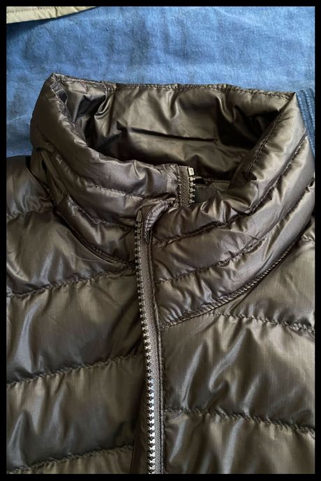 Detail photo of the collar on Quince's Women's Lightweight Down Packable Puffer Jacket in black.