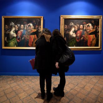 Visitors compare two copies of the 16th century painting by Italian artist Lorenzo Lotto 