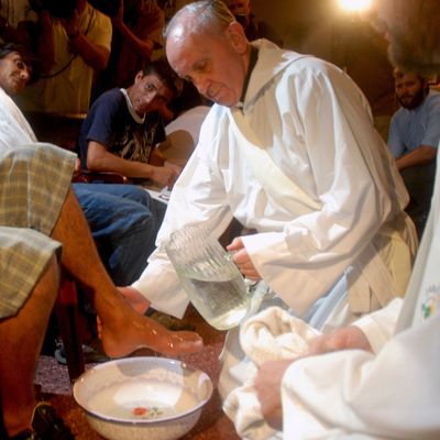 Pope Francis washing men's feet.