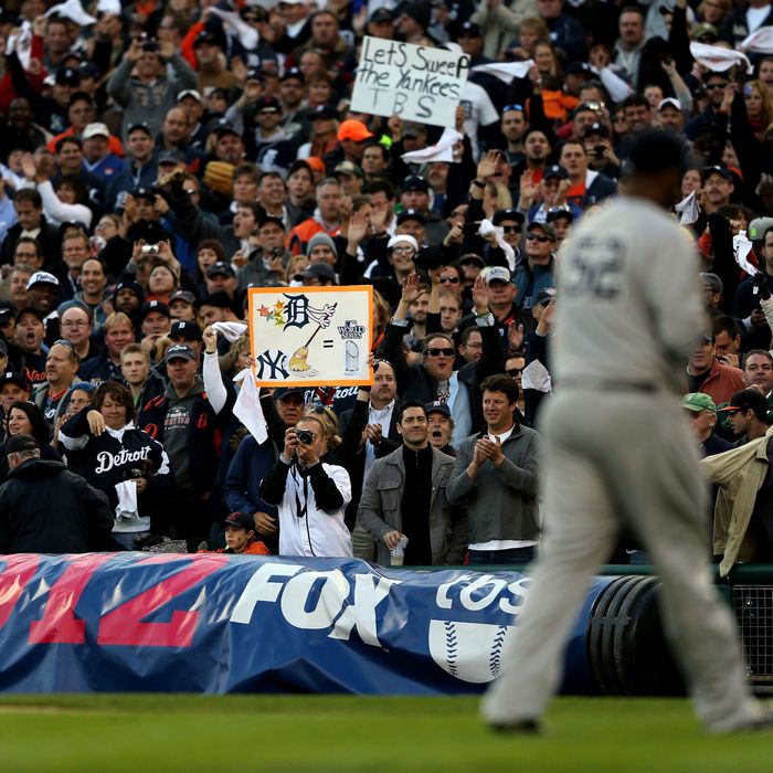 Fans of the Detroit Tigers cheer and hold up signs as CC Sabathia #52 of the New York Yankees walks back to the dugout after he was taken out of the game in the bottom of the fourth inning during game four of the American League Championship Series at Comerica Park on October 18, 2012 in Detroit, Michigan. 
