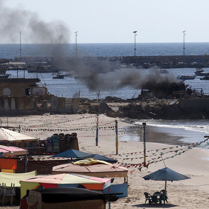 Smoke billows from a beach shack following an Israeli military strike, on July 16, 2014 in Gaza City which killed four children, medics said. All four were on the beach when the attack took place, emergency services spokesman Ashraf al-Qudra said, with several injured children taking refuge at a nearby hotel where journalists were staying. AFP PHOTO / THOMAS COEX (Photo credit should read THOMAS COEX/AFP/Getty Images)