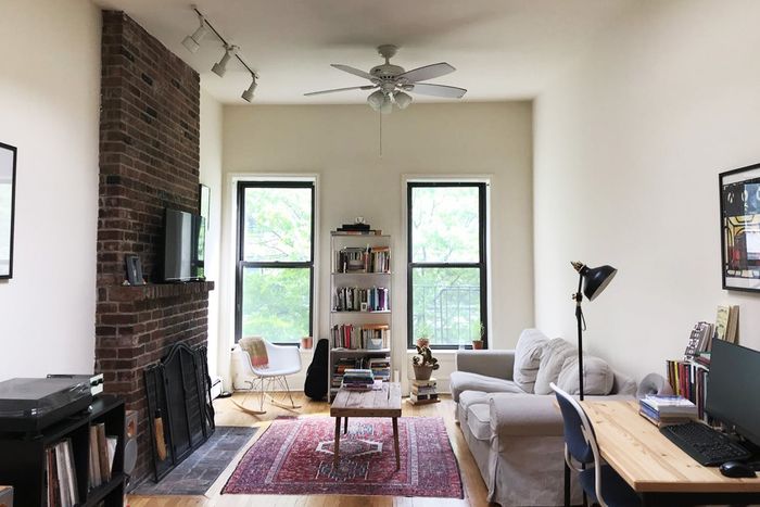 Living room with two windows and a brick fireplace.