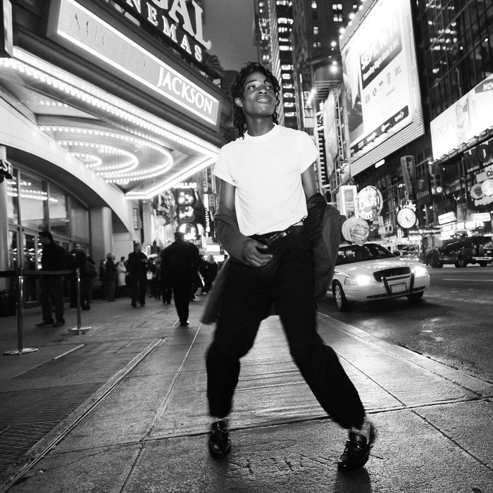 A Michael Jackson impersonator dances on a New York City sidewalk.